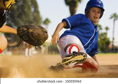 Full length of softball player sliding into home plate - Powered by Shutterstock