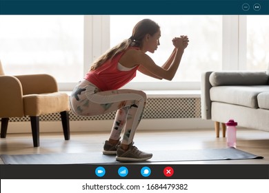 Full length software videoconference application view young attractive strong fit woman in sportswear deeply squatting indoors. Healthy young female trainer recording video workout workshop at home.