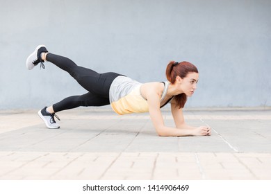 Full Length Of Strong Woman In Plank Position With Leg Up