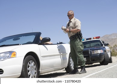 Full Length Of Traffic Officer Writing Ticket