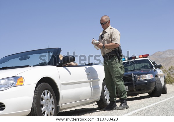 Full length of\
traffic officer writing\
ticket