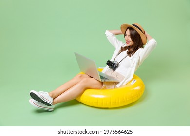 Full length traveler tourist woman in casual clothes rest in inflatable swim ring use laptop pc computer isolated on green background Passenger travel abroad weekend getaway Air flight journey concept - Powered by Shutterstock