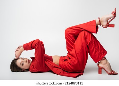 full length of trendy young woman in red suit lying on grey - Shutterstock ID 2124893111