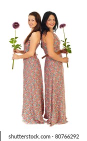 Full Length Of Two Beautiful Women In Same Dress Holding Flowers Isolated On White Background