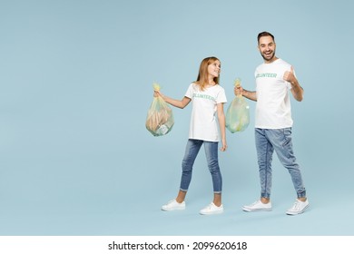Full length two young friends couple teen girl man wear white tshirt green volunteer hold bag trash walk go isolated on pastel blue color background Voluntary free team work help charity grace concept - Shutterstock ID 2099620618