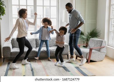 Full Length View African Ethnicity Family Dancing Together In Living Room At New First Home, Young Couple And Little Kids Having Fun Listening Music Enjoy Life Cool Weekends Free Time Activity Concept