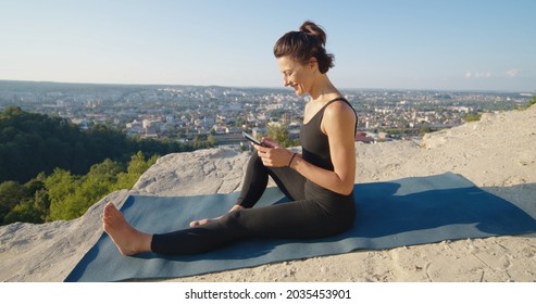 Full Length View Of The Calm Caucasian Woman Holding Her Smartphone And Feeling Good At The Nature After Morning Exercises And Yoga Training