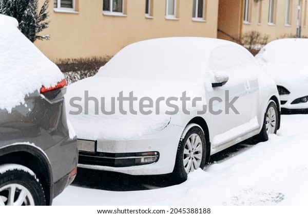 Full length\
view of the cars suffered after snow cyclone. Rows of a cars\
standing on a snowy road. Winter concept\
