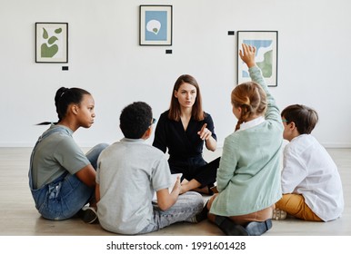 Full length view at diverse group of children sitting in circle during class in art gallery with female teacher - Powered by Shutterstock