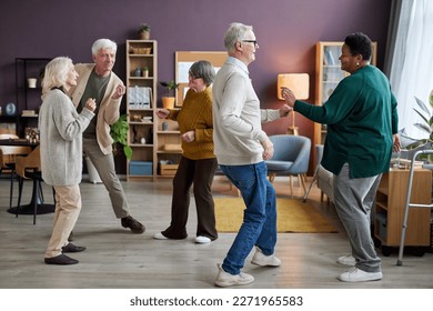 Full length view at group of senior people dancing in retirement home interior and enjoying activities - Powered by Shutterstock