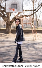 Full Length View Of Happy African American Woman In Jacket Near Basketball Outdoor Court