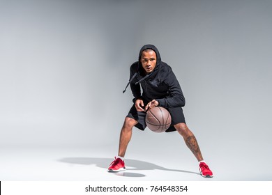 Full Length View Of Sporty African American Man Playing With Basketball Ball And Looking At Camera On Grey 