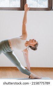 Full Length View Of The Sporty Mature Woman Practicing Yoga, Stretching In Revolved Downward Facing Dog Exercise, Working Out At Home