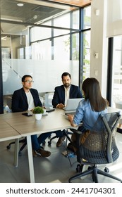 Full length view of two human resources workers listening to a woman during a job interview