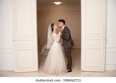 Full Length View Of Young Newlyweds Holding Hands Near Entrance To Bedroom