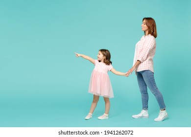 Full length woman in pink clothes have fun with child baby girl 5-6 years old. Mommy little kid daughter walk go step isolated on pastel blue azure background studio. Mother's Day love family concept - Shutterstock ID 1941262072