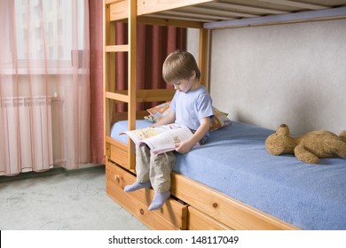 Full Length Of Young Boy Reading Book On Bunk Bed