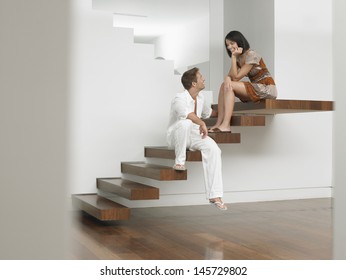 Full length of a young couple sitting on stairs in house - Powered by Shutterstock