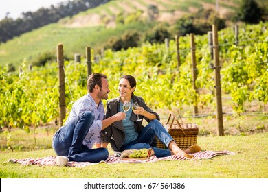 Full length of young couple toasting wineglasses at vineyard on sunny day - Powered by Shutterstock