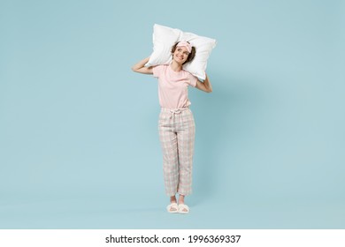 Full length young dreamful happy woman 20s in pajamas jam sleep eye mask rest relax at home holding pillow look aside isolated on pastel blue color background studio. Good mood night bedtime concept. - Shutterstock ID 1996369337