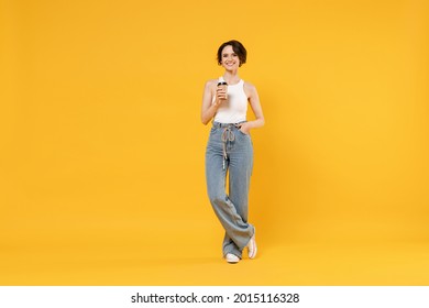 Full Length Young Fun Happy Smiling Woman 20s With Bob Haircut Wear White Tank Top Shirt Hold Takeaway Delivery Craft Paper Brown Cup Coffee To Go Isolated On Yellow Color Background Studio Portrait