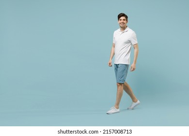 Full length young fun happy unshaven cheerful caucasian man 20s wear white basic t-shirt looking camera walking go isolated on pastel blue color background studio portrait. People lifestyle concept - Shutterstock ID 2157008713