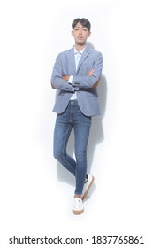 
Full Length Young Handsome 
 Man Wearing Suit With Blue Shirt And Blue Jeans With White Sneakers With Arms Crossed

