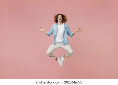 Full Length Young Man 20s With Long Curly Hair In Casual Clothes Hold Spread Hand In Yoga Om Aum Gesture Relax Meditate Try To Calm Down Jump High Isolated On Pastel Plain Pink Wall Background Studio.