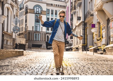 Full length of young man in casual clothing wandering empty street and having fun with morning coffee while walking outdoors. Summer trip. Tourist exploring the city - Powered by Shutterstock