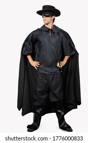 Full length of young man dressed as Zorro against gray background