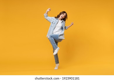 Full Length Of Young Overjoyed Excited Fun Student Happy Woman 20s In Denim Shirt White T-shirt Do Winner Gesture Clench Fist Celebrating Dancing Isolated On Yellow Color Background Studio Portrait.