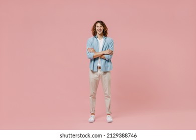 Full Length Young Smiling Happy Man 20s With Long Curly Hair Wear Blue Shirt White T-shirt Hold Hands Crossed Folded Look Camera Isolated On Pastel Plain Pink Color Wall Background Studio Portrait.