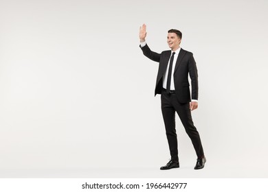 Full Length Young Smiling Successful Employee Business Corporate Lawyer Man Wear Classic Formal Black Grey Suit Shirt Tie Work In Office Walk Waving Hand Greeting Isolated On White Background Studio