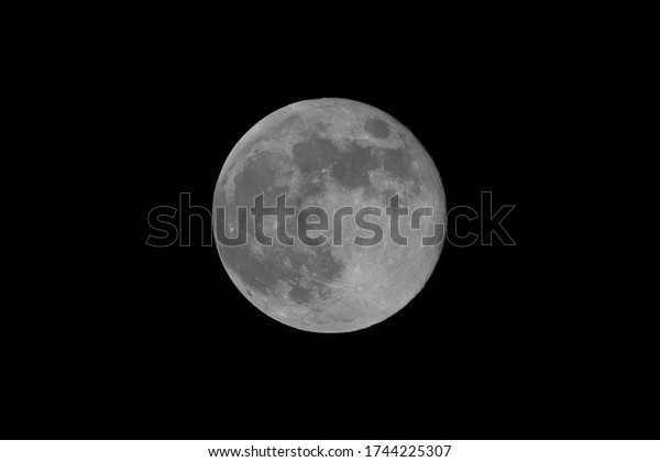 Full May Moon Flower Moon showing surface\
details craters, seas and moon face\
sharp