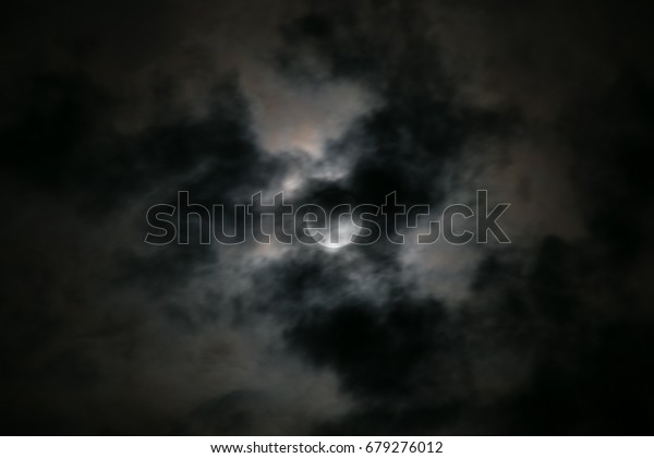 full moon with bright clouds and the moon\
as spotlight in a dark night sky in\
bavaria