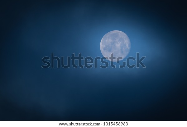 Full moon\
with clouds and fog in the early\
morning