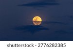full moon in clouds at sunset