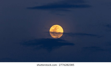 full moon in clouds at sunset
