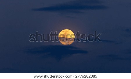 full moon in clouds at sunset