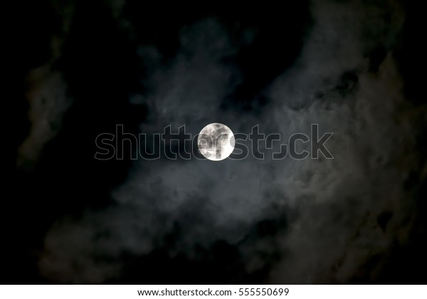 Full moon in the cloudy\
night sky with