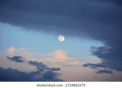 Full Moon in Cloudy Sky with Dramatic Evening Light                               