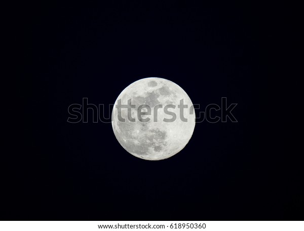 Full moon with craters and texture by night against\
dark sky
