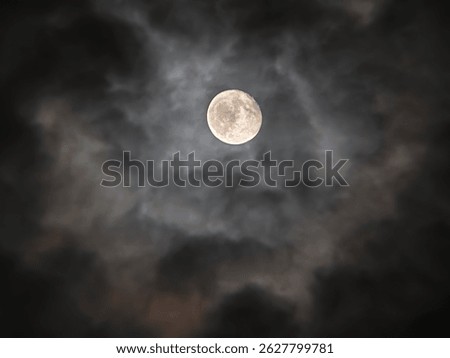 full moon in dark cloudy sky