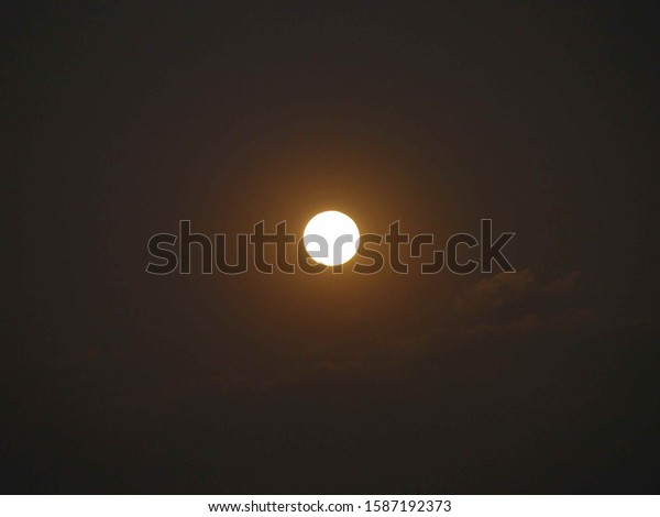 full moon  during evening with  a light cloud and\
strong moon light