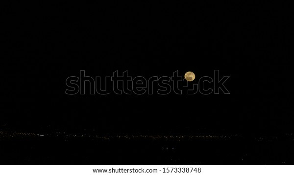 A full\
moon floating above the city of San\
Francisco