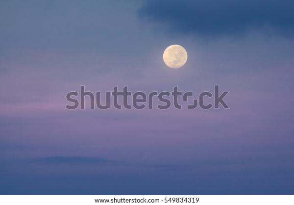 Full moon at foggy\
and cloudy background