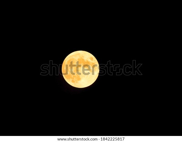 Full Moon Lights Up Dark Sky with Yellow\
Moon Light in Closeup of Full Moon\
Astronomy