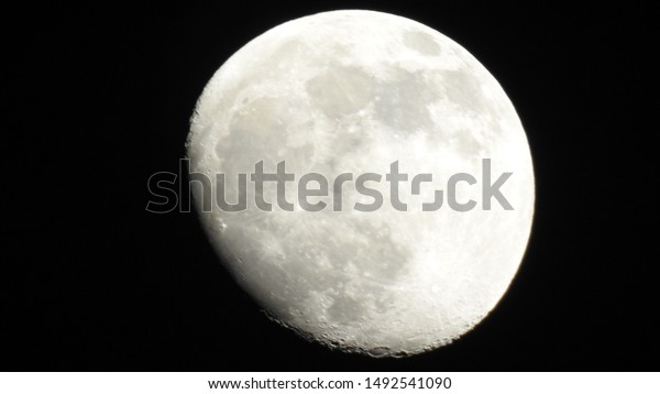 A full moon is the lunar phase that occurs\
when the Moon is completely illuminated as seen from Earth. Big\
moon in its full phase with detailed craters visible on its edges,\
all in a black background,