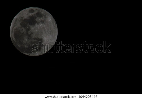 Full\
moon on black background. It is a black and white image that see\
details on the surface. Moonlight without\
stairs