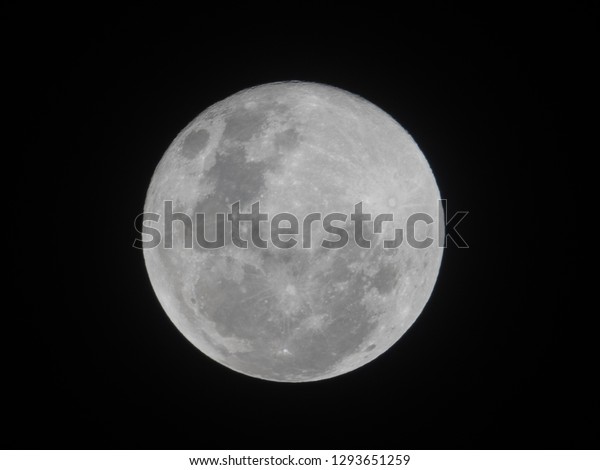 Full moon on dark night sky. The full moon is lunar\
phase when It appears fully illuminated from Earth\'s perspective.\
It occurs when Earth is located between Sun and Moon appears as a\
circular disk